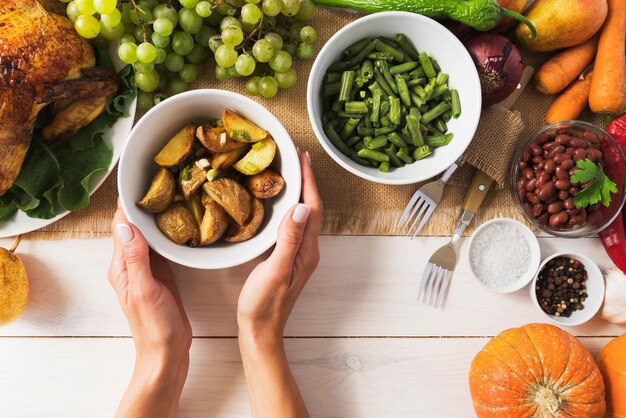 Close-up hands holding bowl of potatoes