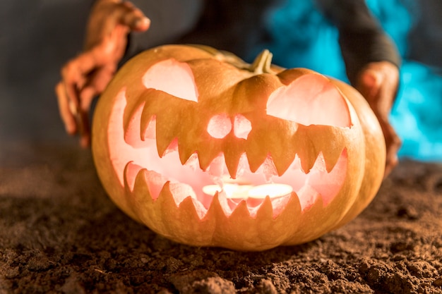 Free Photo close-up hands holding carved pumpkin