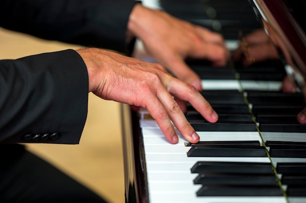 Close-up hands holding chords on classical piano