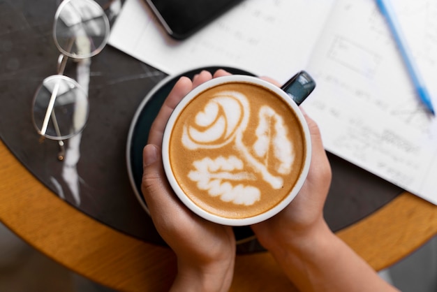 Free photo close up hands holding coffee cup