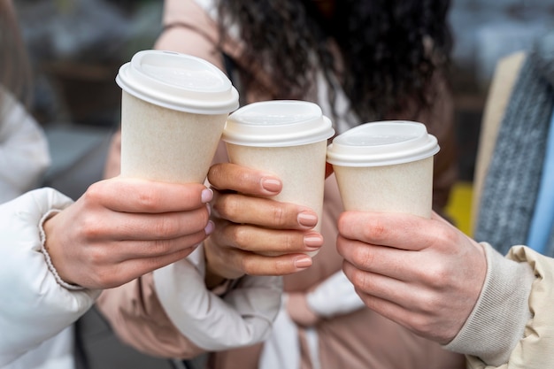 Free photo close up hands holding coffee cups