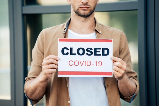 Free photo close-up hands holding covid19 sign