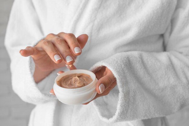 Close-up hands holding cream container