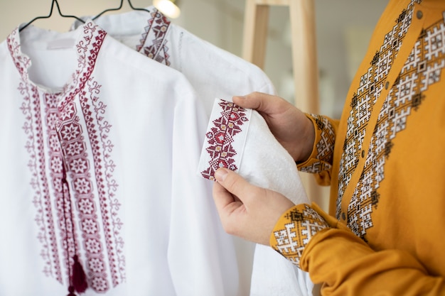 Free photo close up hands holding embroidered shirt