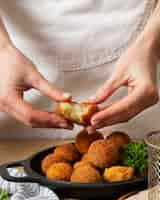 Free photo close up hands holding food croquette