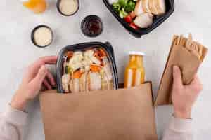 Free photo close up hands holding food pack and cutlery