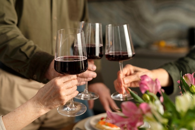 Close up hands holding glasses with wine