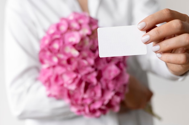 Close up hands holding hydrangea bouquet and note