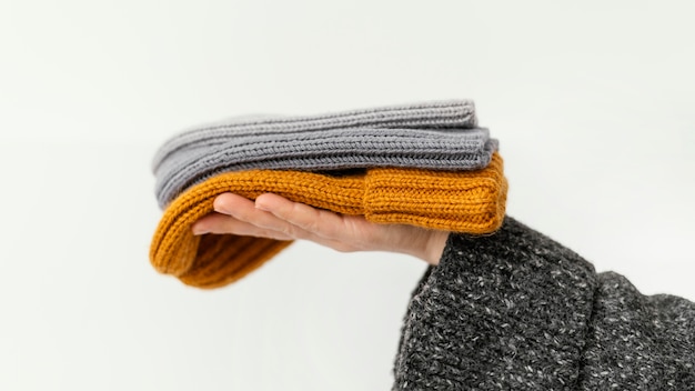 Free photo close-up hands holding knitted hats