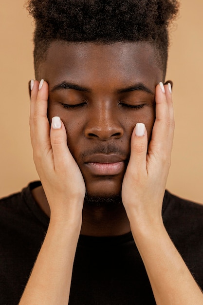 Free photo close-up hands holding man face