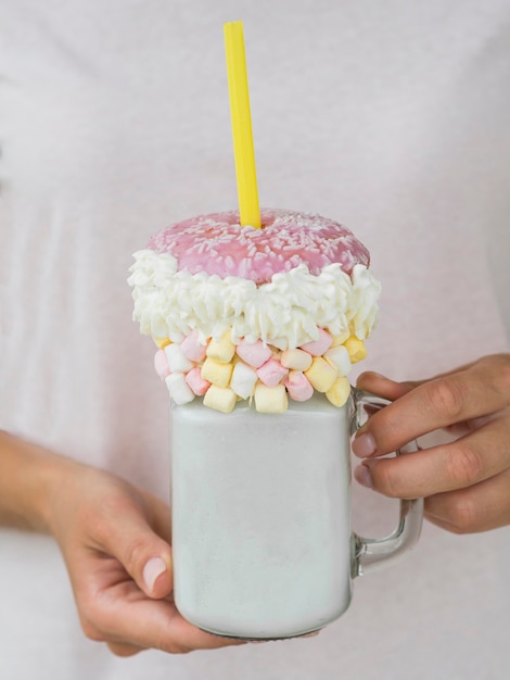 Close-up hands holding milkshake jar