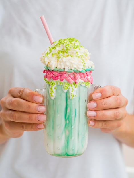 Free photo close-up hands holding milkshake