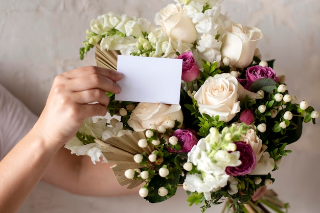 Free photo close up hands holding note and bouquet