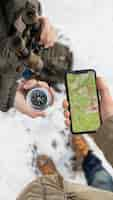 Free photo close up hands holding phone and compass