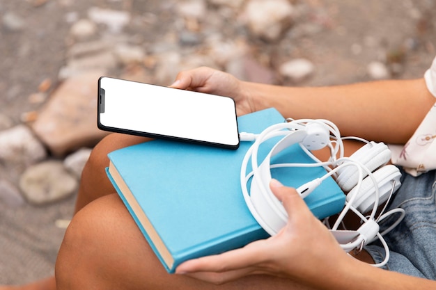 Close-up hands holding phone and headphones