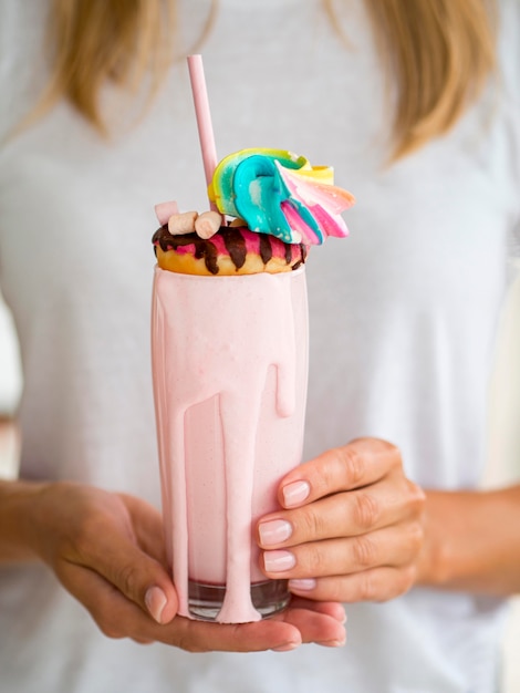 Free photo close-up hands holding pink shake