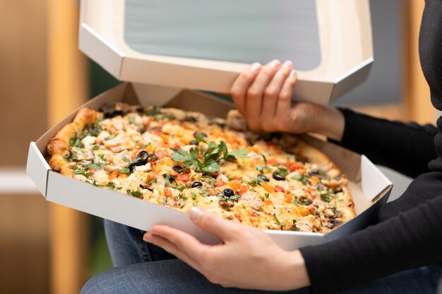 Close up hands holding pizza boxes