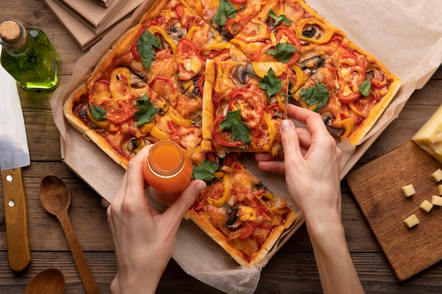 Close up hands holding pizza and drink