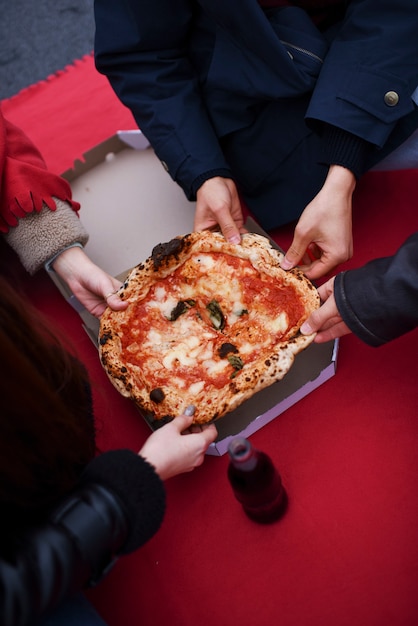 Free photo close up hands holding pizza