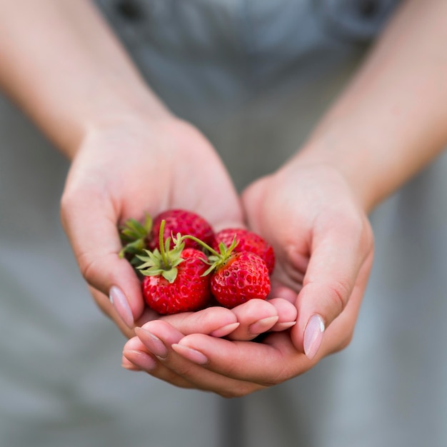 Free photo close-up hands holding strawberries