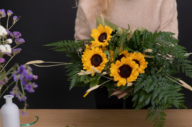 Free photo close up hands holding sunflowers