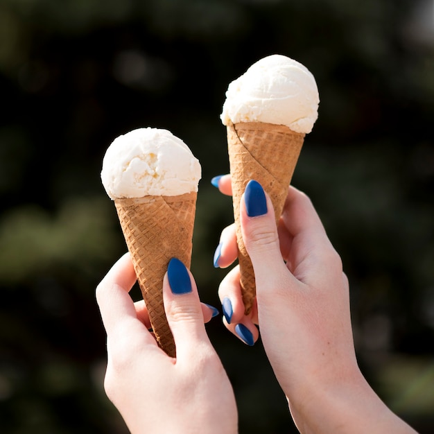 Free Photo close-up hands holding tasty ice creams