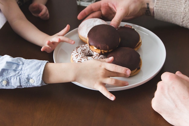 Free photo close-up of hands picking donuts