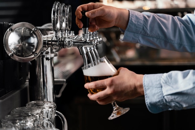 Close-up hands pouring beer in glass