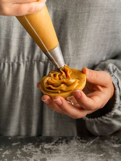 Free Photo close up  hands preparing alfajores with cream