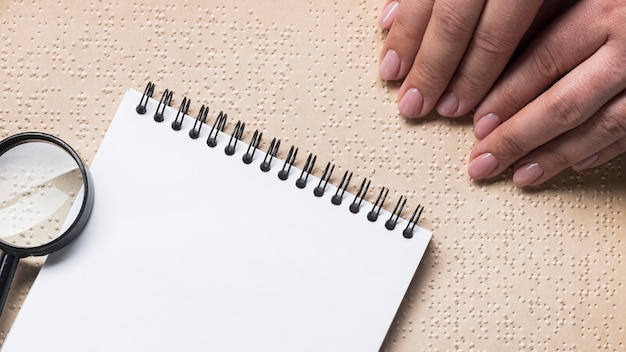 Close-up hands reading braille book