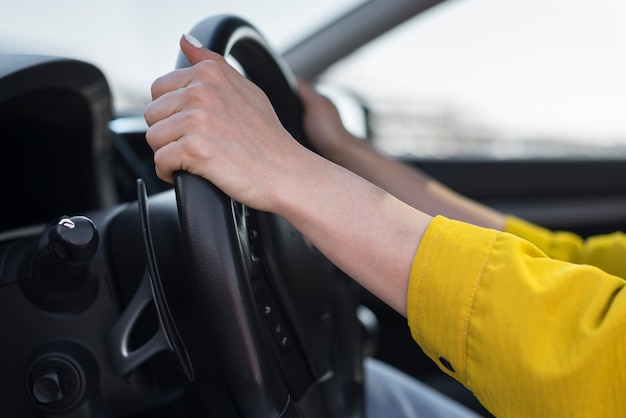 Free photo close-up hands on the steering wheel