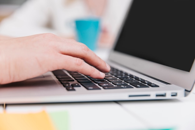 Close-up of hands using laptop