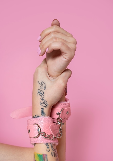 Close up hands wearing pink handcuffs