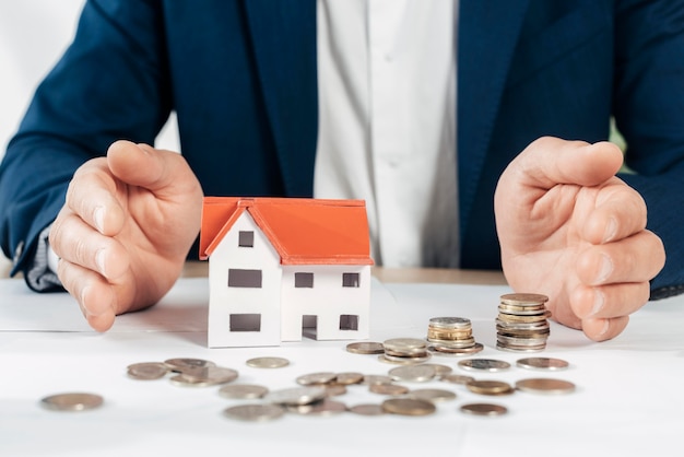 Free photo close-up hands with coins and house