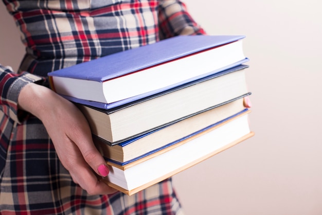 Close-up of hands with four thick books