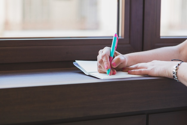 Free photo close-up of hands with pen writing in a notebook