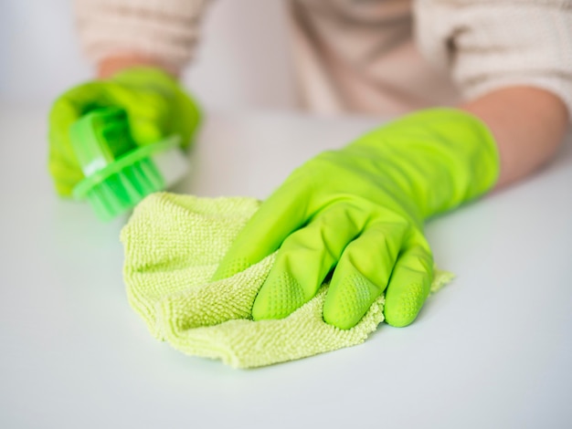 Free photo close-up hands with rubber gloves holding cloth