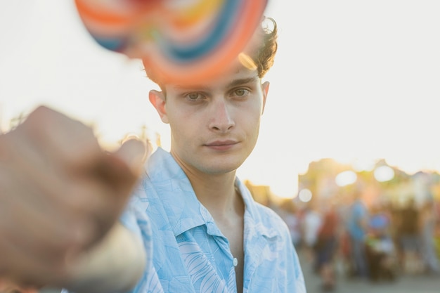 Free Photo close-up handsome guy with colorful lollipop