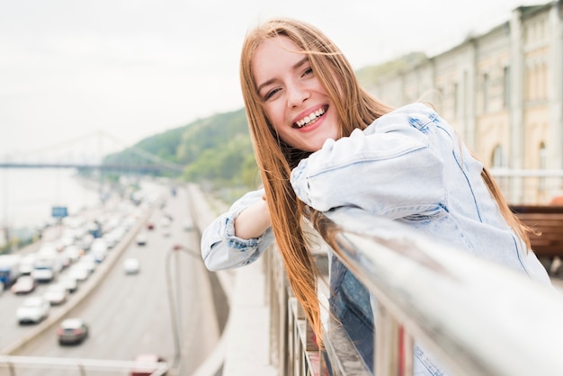 Free Photo close-up of happy beautiful young woman standing near railing