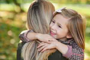 Free photo close up of happy girl embracing her mommy