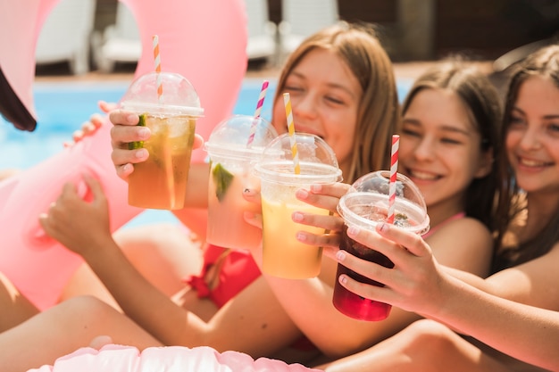 Free photo close-up happy girls giving a toast with each other