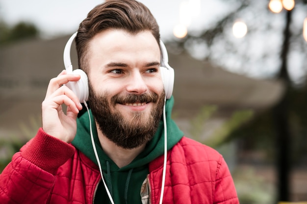 Free photo close-up happy guy with headphones and red jacket