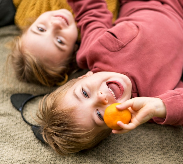 Free Photo close-up happy kids with clementine