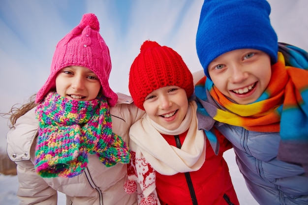 Close-up of happy kids with wool hats and scarves