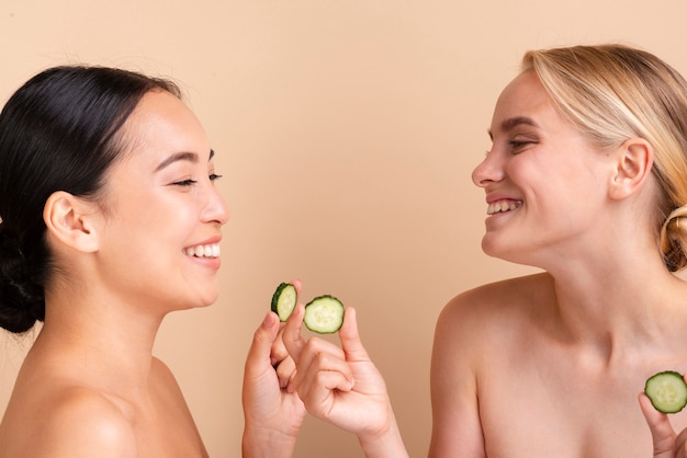 Close-up happy models posing with cucumber slices