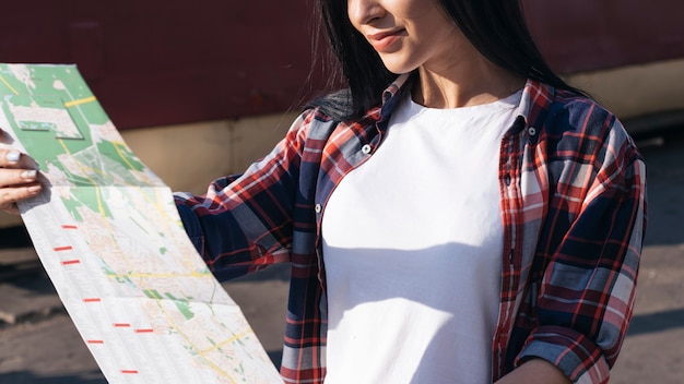 Free Photo close-up of happy woman reading map at outdoors