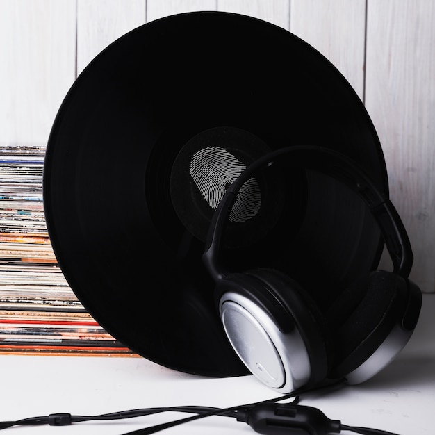 Free Photo close-up headphones near vinyl record with fingerprint