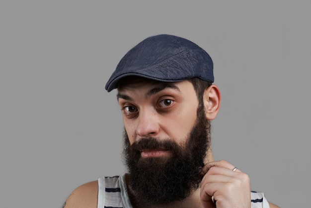 Close up high detailed portrait of caucasian bearded man isolated on grey background and look to the camera.