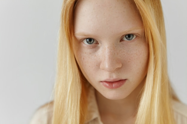 Free Photo close up highly-detailed indoor shot of extraordinary gorgeous european blonde girl with clean healthy freckled skin and blue eyes