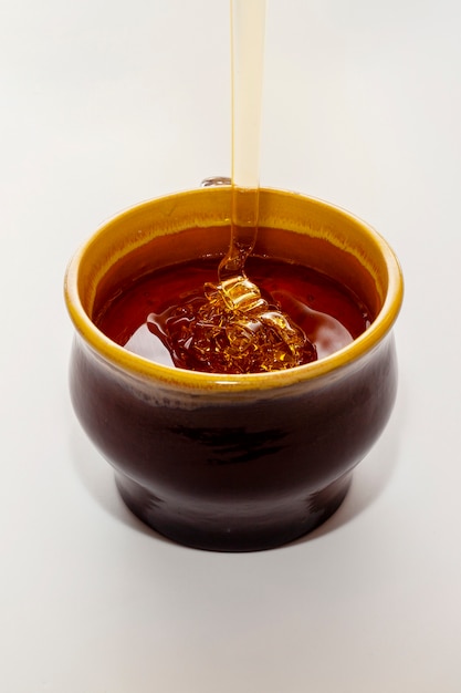 Close-up honey pouring into bowl